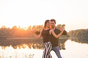 Kizomba, bachata, zouk and latin social dance concept - Man and woman dancing over nature background