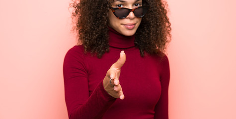 Dominican woman with turtleneck sweater handshaking after good deal