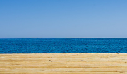 Fototapeta premium Wooden pier, sea and blue sky background. Holiday travel concept. Empty space for summer banner. Relax during vacation wallpaper