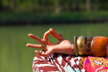 closeup of woman hand in mudra gesture practice yoga meditation outdoor by the lake summer day