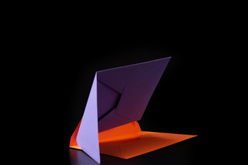 purple and orange envelopes sideways on black background