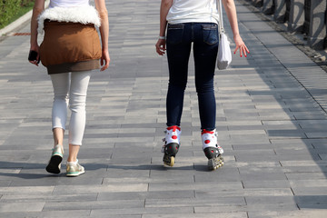 Riding on roller skates, two girls walking on the street. Concept of youth, sport, lifestyle