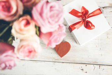 pink roses with gift box  and heart on desk