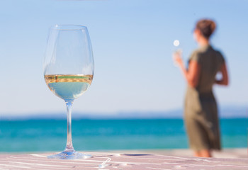 glass of red wine on table over young woman Lazise backgound