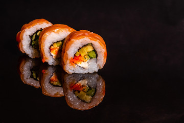 Fresh and tasty sushi on dark background. It can be used as a background