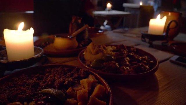 Retro vintage candle light and medieval food on the wooden table in the dark