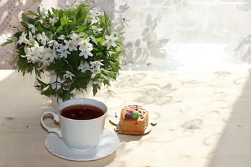 A cup of tea and a cake on a sunny table, a bouquet of spring flowers for mood, diet food and a healthy lifestyle in the village, a beautiful morning in the village, a delicious dessert