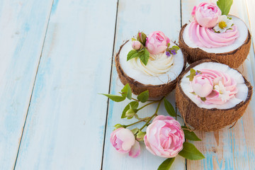 Coconut cupcakes with flowers, strawberries and cheese cream