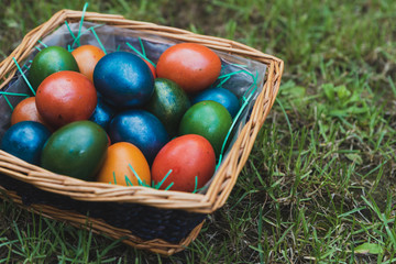 Easter eggs in a wicker basket on the grass