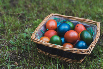 Easter eggs in a wicker basket on the grass