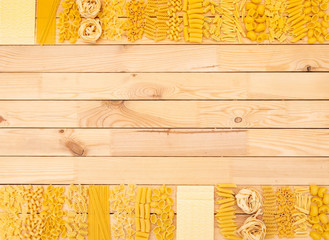 Background of wood natural panel full of kind of pasta making the borders. Healthy mediterranean diet