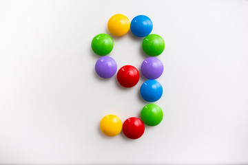 Digit 9 made from children's toys. Multicolored figures for games