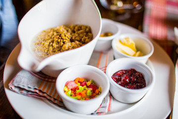 Traditional English breakfast. Oatmeal, jam, butter and dried fruit on plate