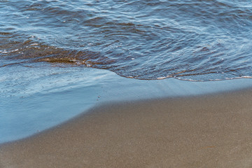 Fantastic soft wave layers on sand at the sea.