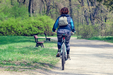 Girl riding a bike in a city park