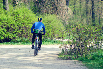 Naklejka premium Cyclist riding a bike in a city park