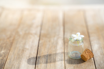 Fototapeta na wymiar Glass bottles have small flowers on the wooden floor.
