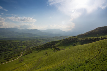 Valley with green grass and mountains at background. Beautiful natural landscape in the summer time in Devichi, Azerbaijan.