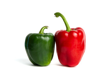 Red and green peppers isolated on a white background. The concept of eating vegetables, providing vitamins and healthy eating. Comparison of red and green peppers.