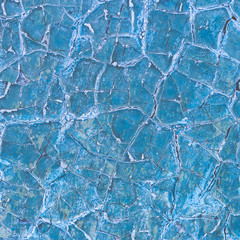 Texture of a dry cracked blue paint on a metal surface. Cracks on the iron wall. Abstract background.