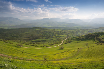 Fototapeta na wymiar Valley with green grass and mountains at background. Beautiful natural landscape in the summer time in Devichi, Azerbaijan.