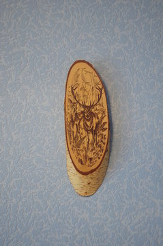 The image of deer on a piece of birch tree, made by the method of wood hanging