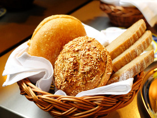 Different types of bread in the basket with white towel served for traditional vienna breakfast.