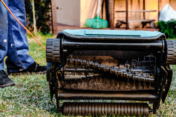 Close-up of an aerator into the soil. Close-up on scarifier blades. Soil scarification. Repairing gardening equipment, broken mower and aerator.