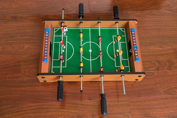 Cropped image of young people and children playing foosball while resting outdoors