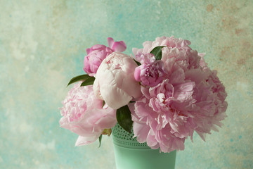 Bouquet of pink peonies in a vase on a light colored background