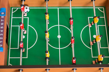 Cropped image of young people and children playing foosball while resting outdoors