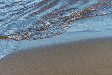 Fantastic soft wave layers on sand at the sea.