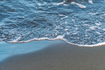 Fototapeta na wymiar Fantastic soft wave layers on sand at the sea.