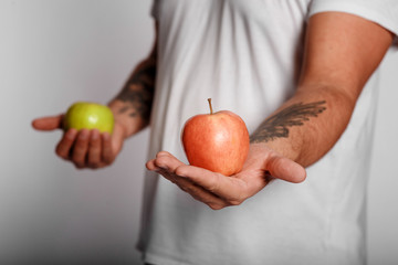 fat man on a white background with an apple in his hands. man chose a healthy lifestyle. 