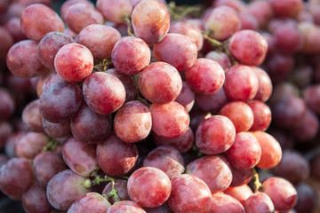 Delicious bunch of a purple grape on sunny day at the market. Closeup.