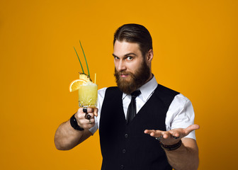 bearded barman with beard holding cocktail in waistcoat