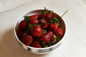 Red fresh strawberry in a bowl on white background with copy space