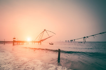 Fototapeta premium Fishing nets silhouette at sunset. Cochin, South India, Kerala