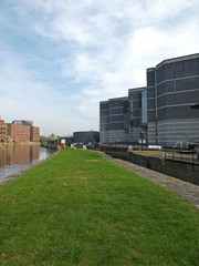 Fototapeta na wymiar the leeds lock entrance to clarence dock with footbridge over the river aire and lock gates and mooring area surrounded by modern apartment developments and knight bridge