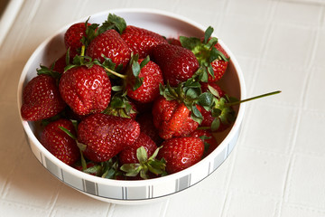 Red fresh strawberry in a bowl on white background with copy space