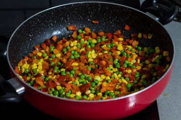 colorful yellow red and green vegetable stew delicious dish from  pepper corn and peas on a friend frying pan dinner light food