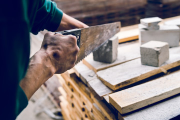 Close up on the construction worker using the hand saw to manually cut the brick insulation material concrete stone