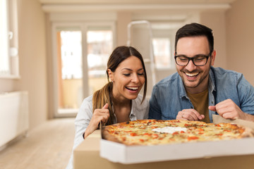 Beautiful couple eating pizza.