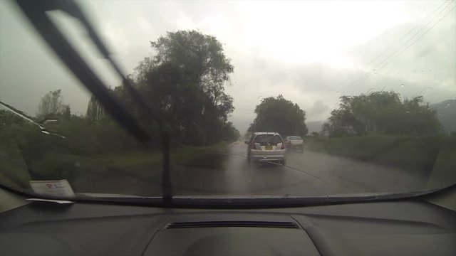 Time lapse- Driving the car during a high storm rain on high vehicles flow in the high way. High dense clouds on the sky .