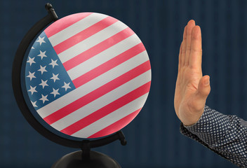 The warning gesture of a man’s hand refers to a globe with a colored national state flag usa