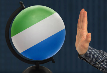 The warning gesture of a man’s hand refers to a globe with a colored national state flag...