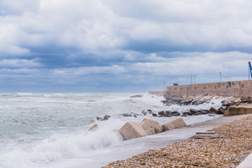 Brave waves of the Adriatic sea beating against the breakwater of the seafront in Bari, Italy