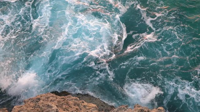 Aerial view of giant blue waves breaking on the rocks during the surf. Action. Sea element