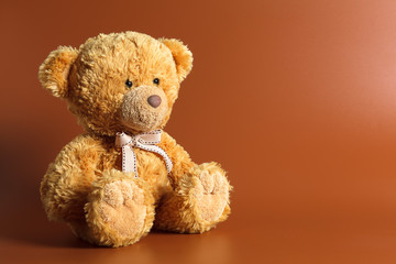 Soft warm cute brown teddy bear on color background. Isolated. Soft brown coffee background. Copy space for text.