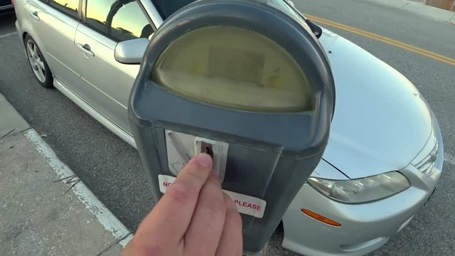 The driver pays for the parking of the car, throws coins into the parking meter